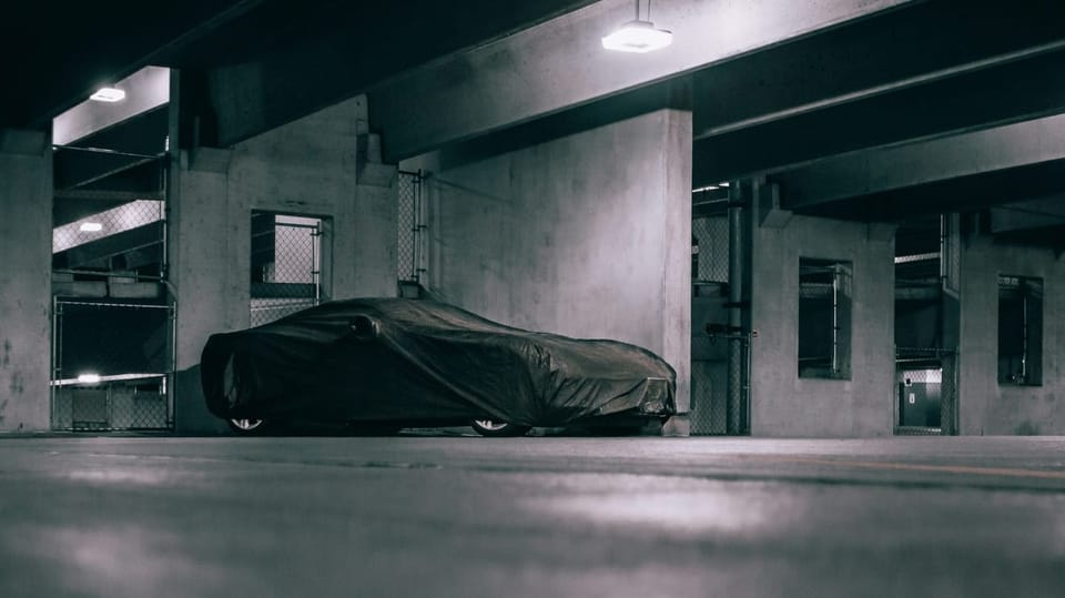 Car covered in a parking garage.